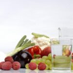 Uomo che beve acqua mentre legge un articolo su come abbassare l'indice glicemico.