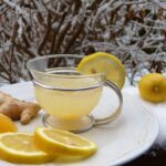Bevanda di acqua con limone e zenzero in un bicchiere, ideale per il dimagrimento.